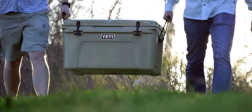 https://huntingwaterfalls.com/wp-content/uploads/2020/04/large-heavy-yeti-cooler-being-carried-by-2-guys.jpg