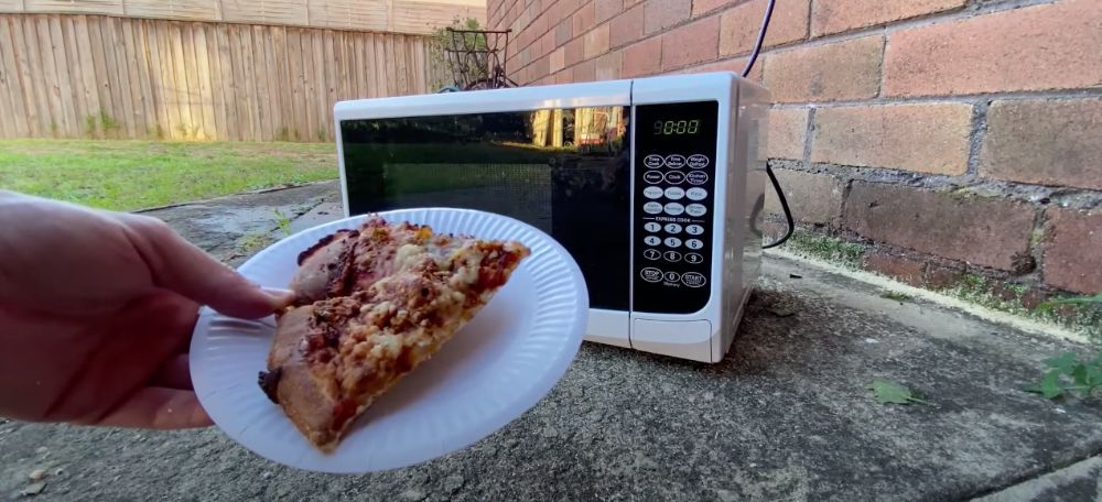 Microwave outside with pizza