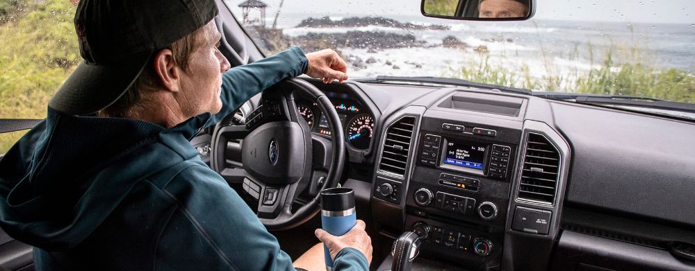 Photo of Man in Car Raining Outside With Yeti Bottle with Hotshot Cap