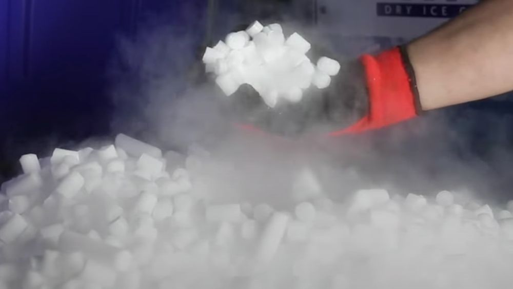 Photo of Gloved Hand Picking Up Dry Ice Pellets
