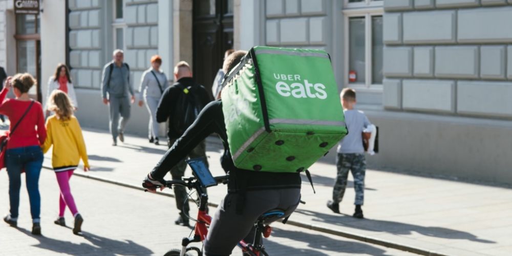 Photo of uber eats delivery bike rider with green backpack